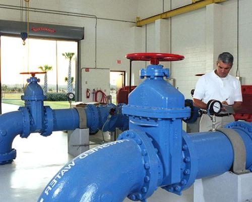 Interior photo from inside the facility. Large blue pipes and valves.